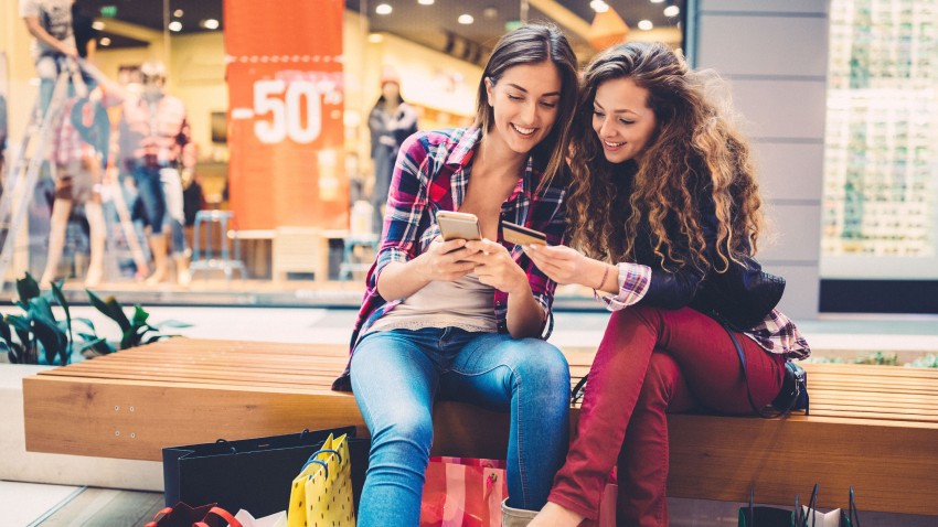 Two women shopping at mall making a credit card purchase